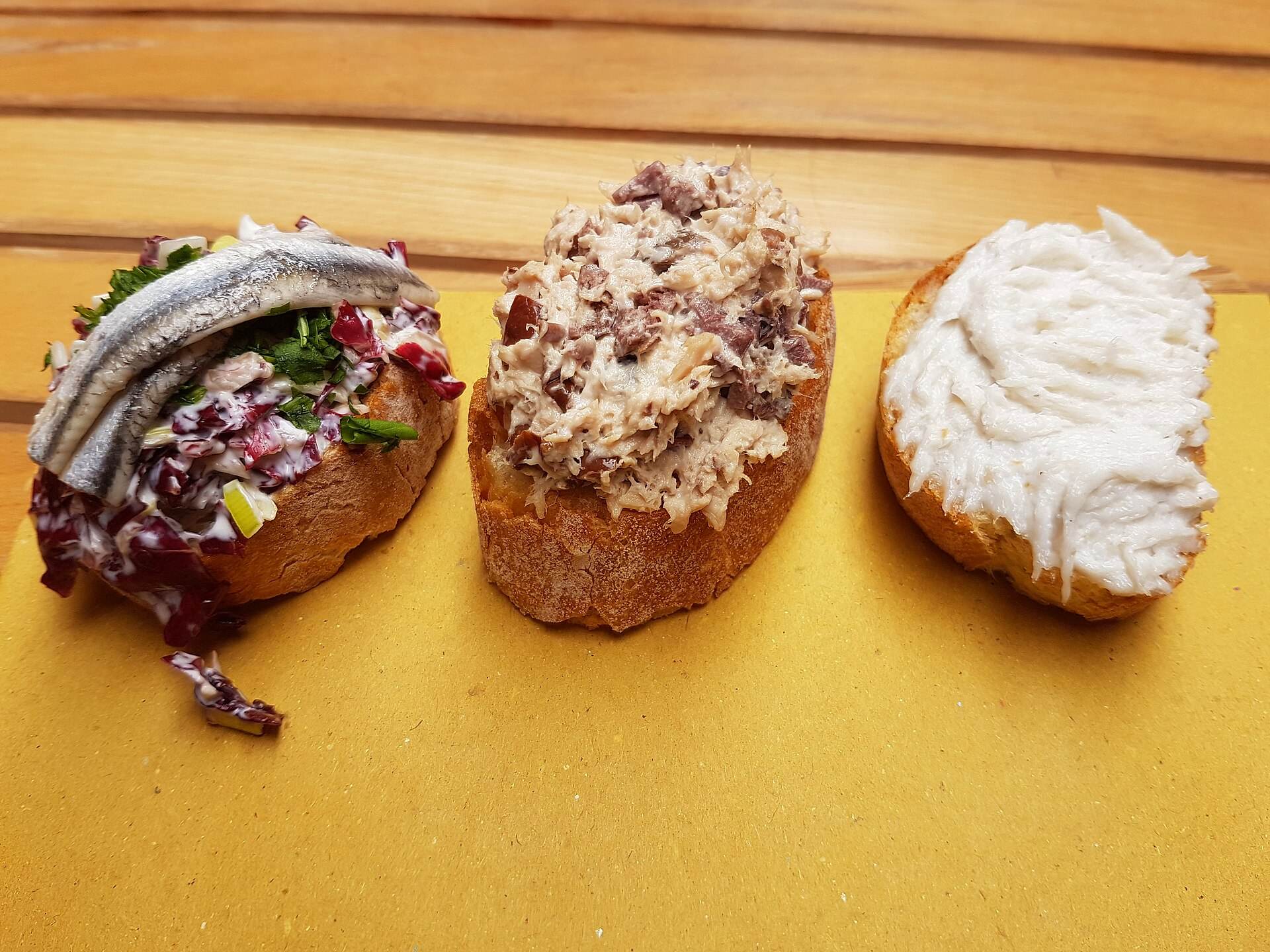 Tre crostini con creme di pesce: a destra il baccalà mantecato