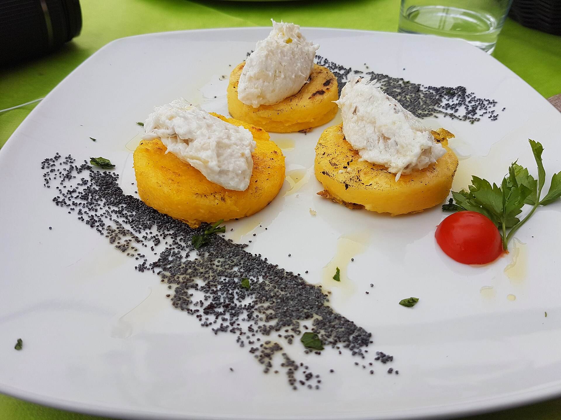 Tre dischi di polenta grigliata con il baccalà mantecato sopra
