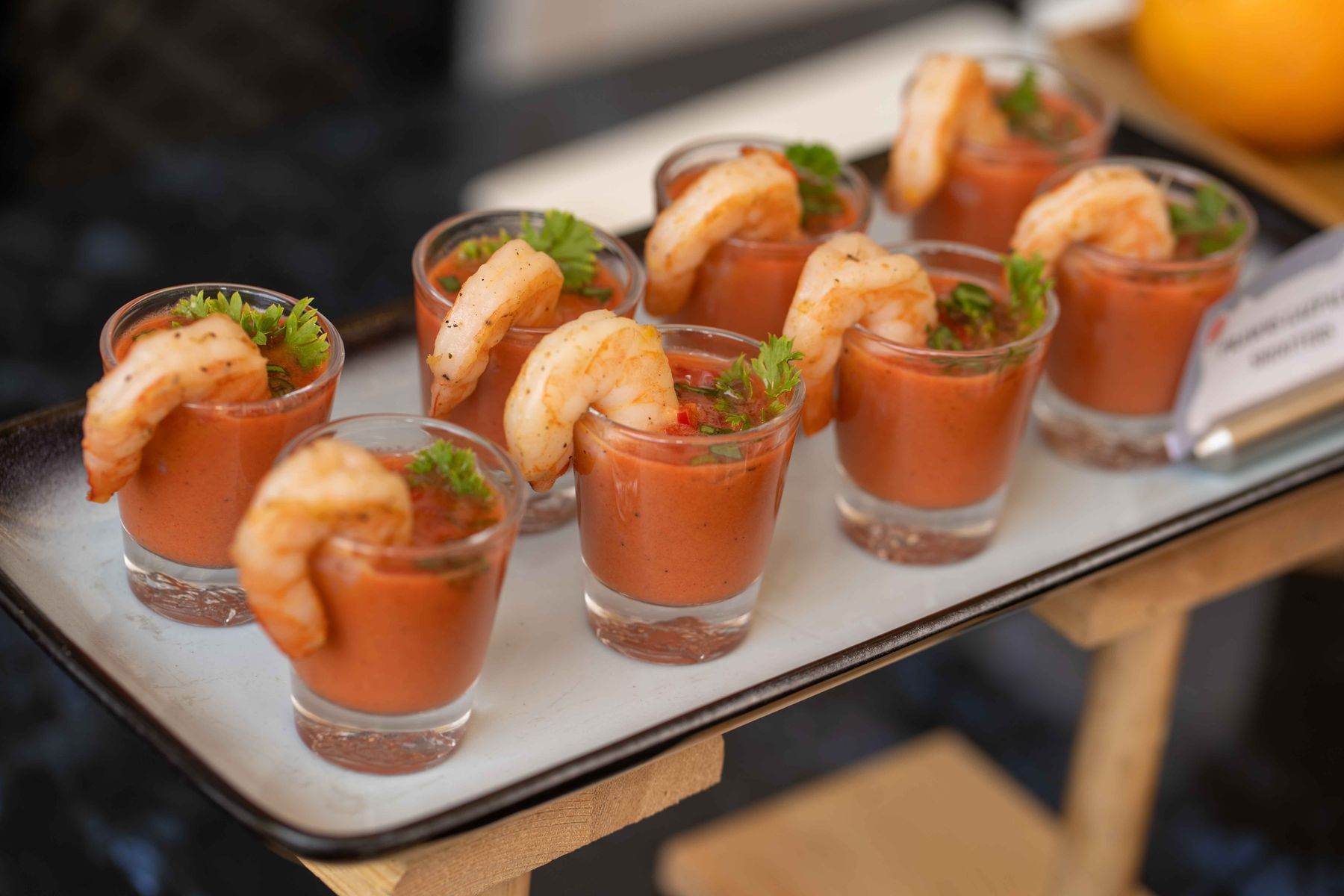 Bicchierini di gazpacho con un gambero, su un vassoio