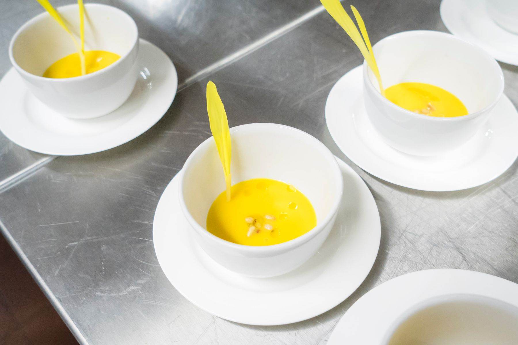 Tazze bianche con una crema gialla sul bancone in acciaio