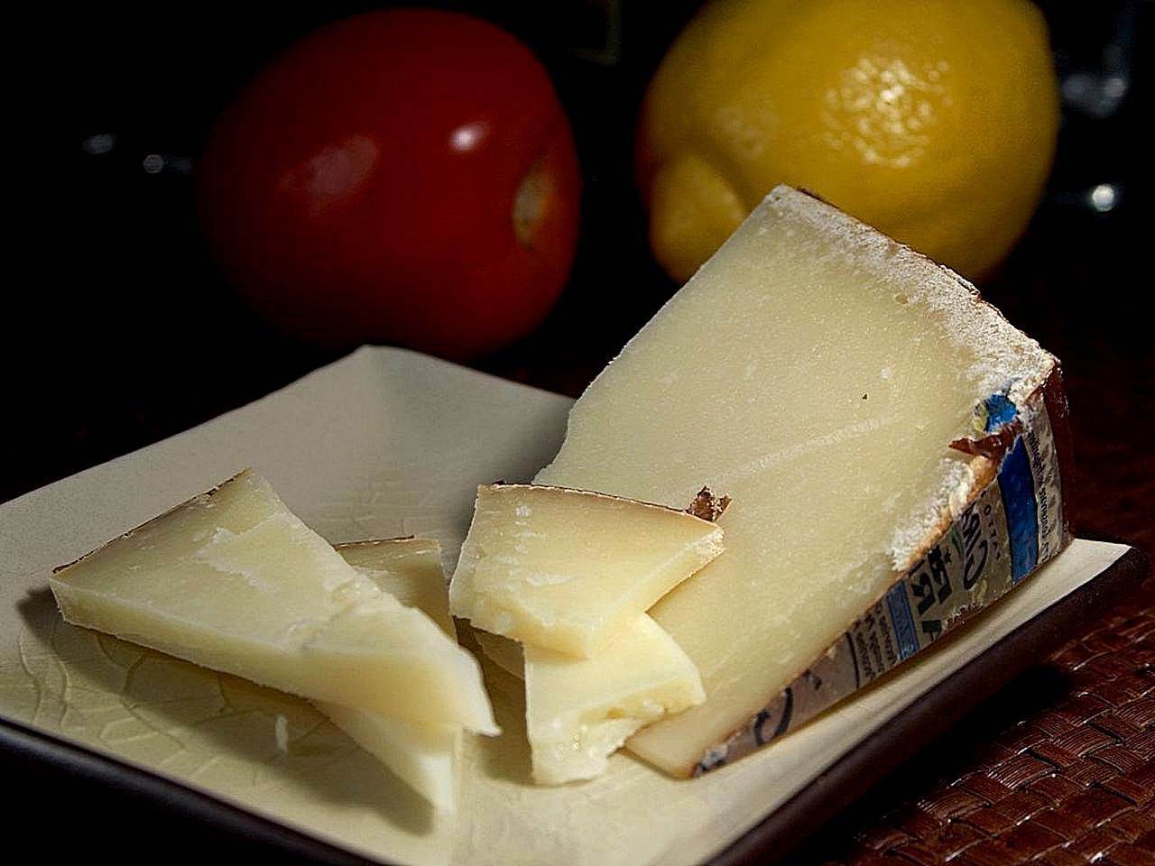 Pecorino sardo, un blocco e alcune fettine, su un piatto