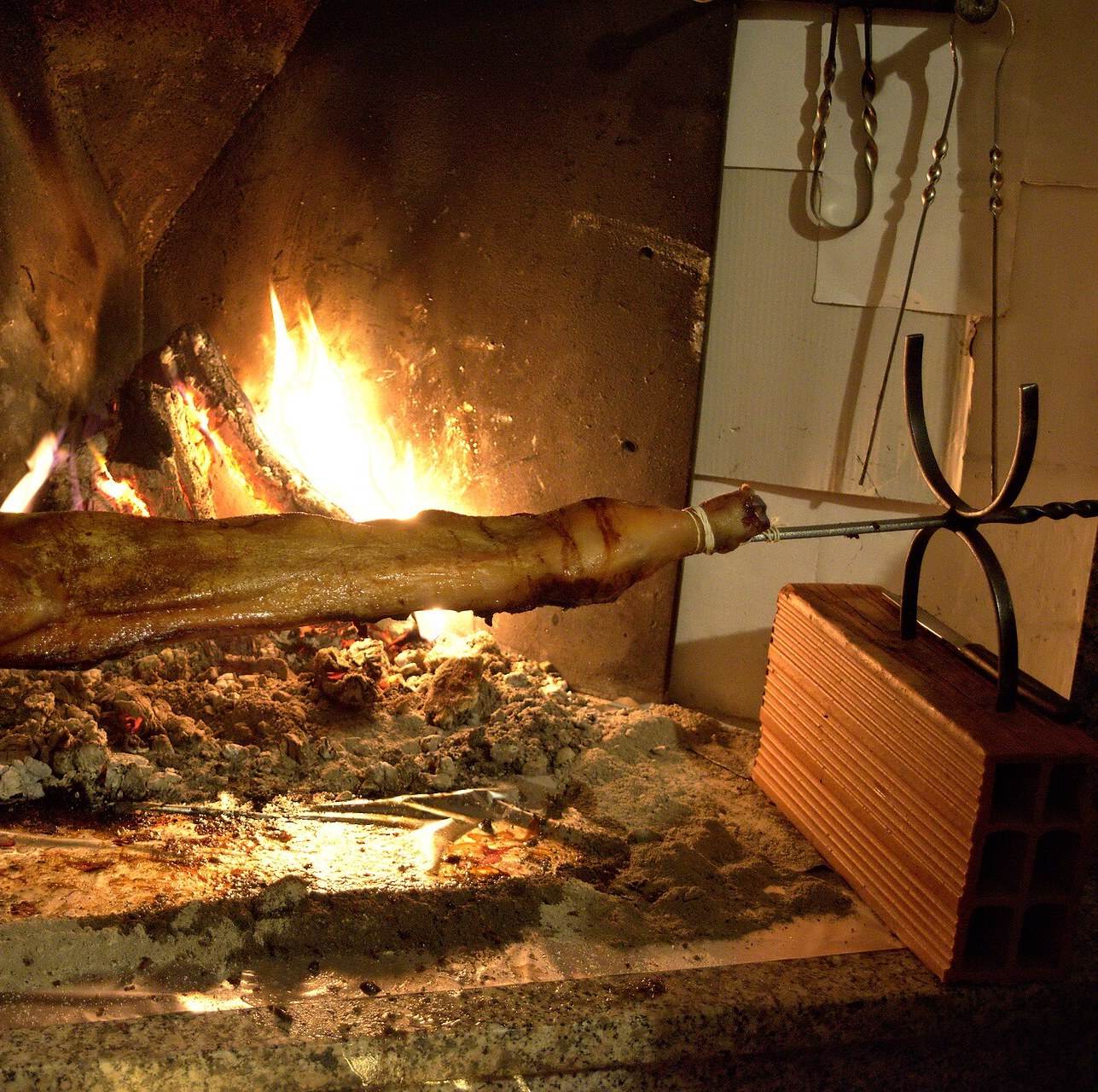 Un porcetto sardo che cuoce al fuoco
