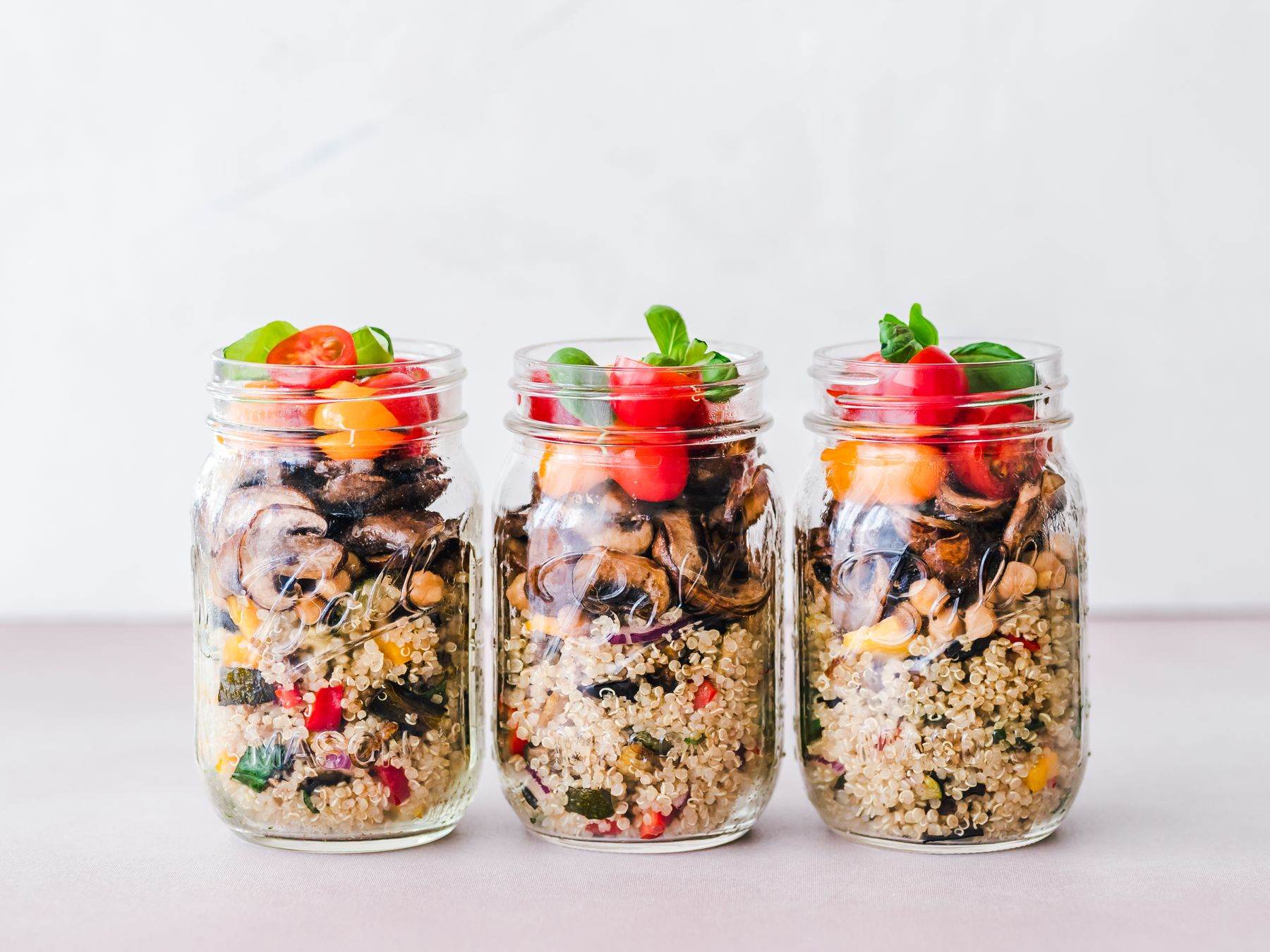 Tre vasetti di vetro con insalata di cereali e verdure